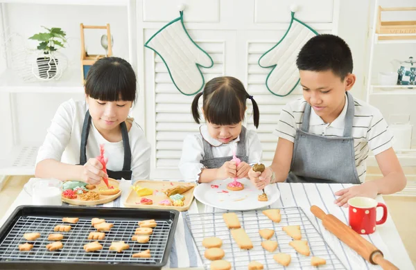 Crianças decorando biscoitos . — Fotografia de Stock