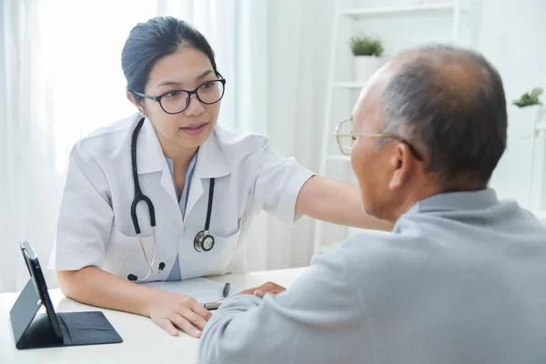 Médico femenino reconfortante paciente masculino mayor . — Foto de Stock