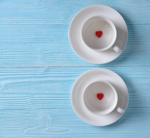 Two Red hearts in two white cups of coffee.