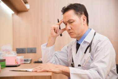 Asya kıdemli erkek doktor düşünme.