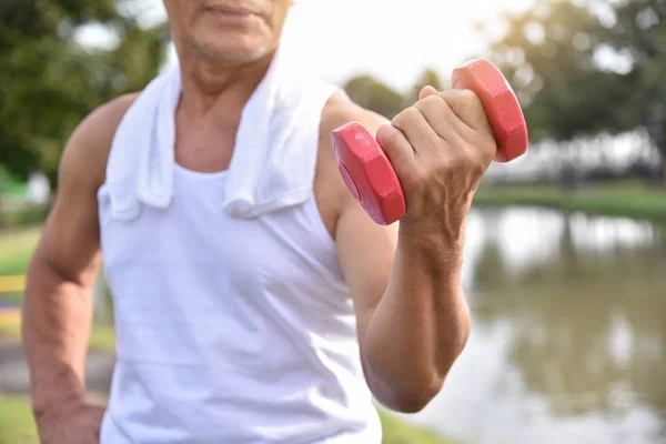 Asian Senior man lifting dumbbell.
