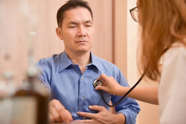 Médico femenino examinando paciente masculino senior . — Foto de Stock