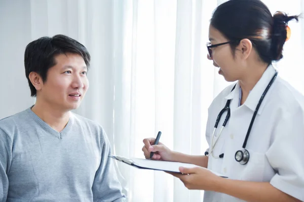 Médico femenino examinando pacientes masculinos . — Foto de Stock