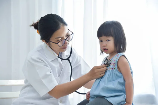 어린 소녀를 조사 하는 여성 의사. — 스톡 사진
