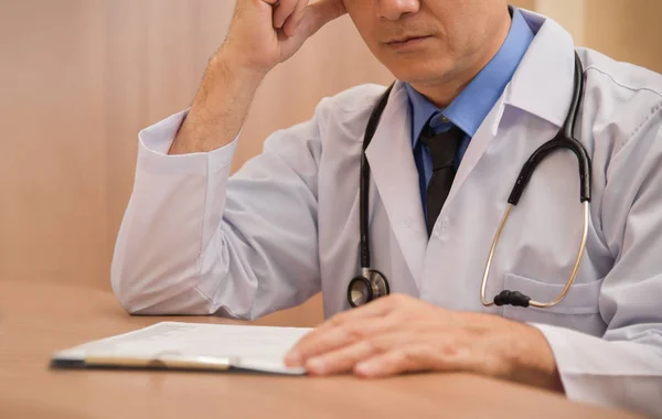 Ásia sênior masculino médico está pensando . — Fotografia de Stock