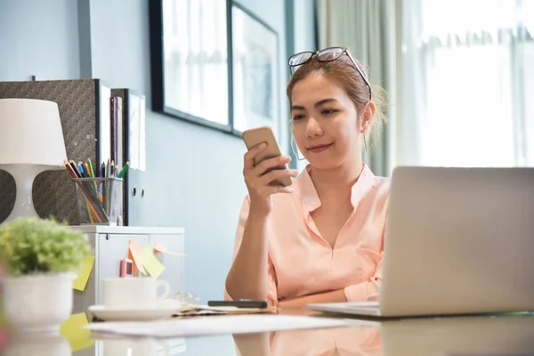 Fiatal ázsiai nő kreatív tervező használ sejt telefon. — Stock Fotó