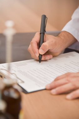 Asyalı erkek doktor bir şeyler panoda yazıyor.