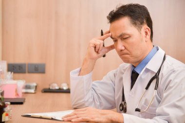 Asya kıdemli erkek doktor düşünme.