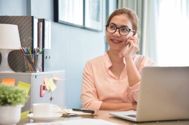 Onun işyerinde cep telefonuyla konuşan kadın yaratıcı tasarımcı.