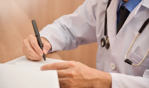 Asiático médico masculino está escrevendo algo na área de transferência . — Fotografia de Stock