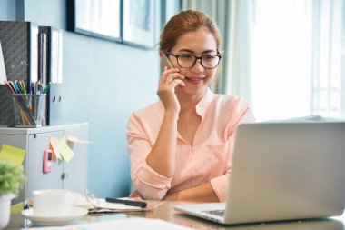 Onun işyerinde cep telefonuyla konuşan kadın yaratıcı tasarımcı.