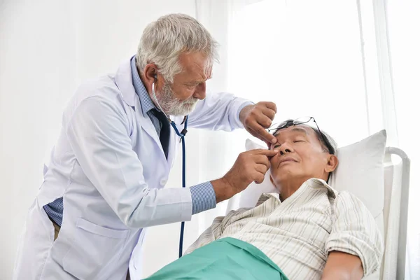 Doctor is checking man patient eyes.