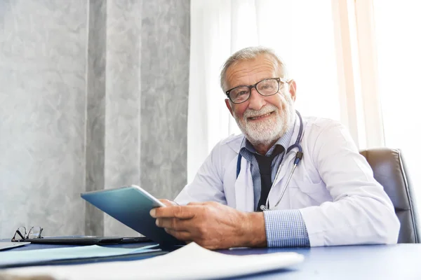 Hombre mayor El doctor sonríe en una habitación médica . — Foto de Stock