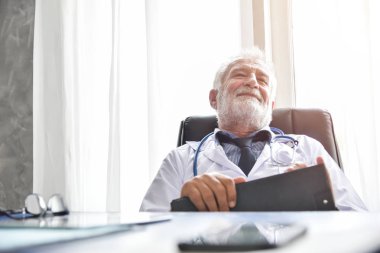 Mutlu kıdemli erkek doktor düşünme.