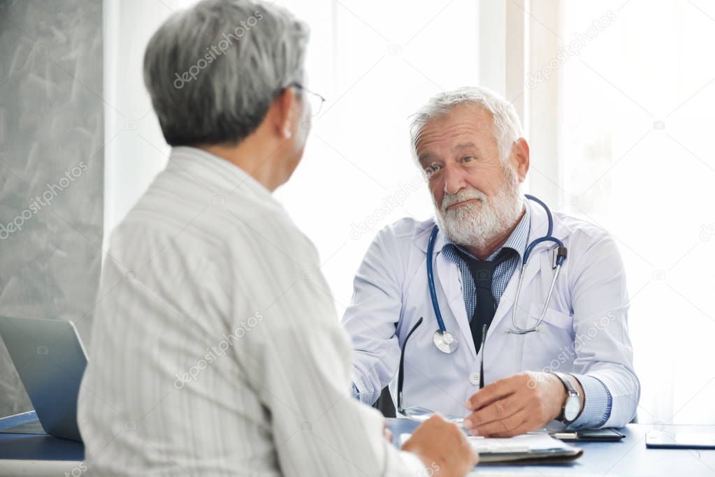 Senior male Doctor is talking with Asian male patient.