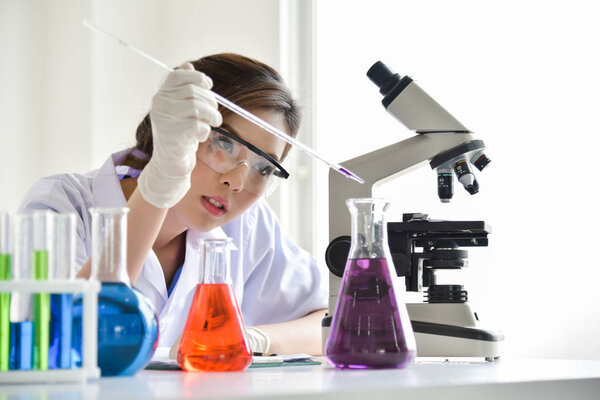 Female Research Scientist is Using Micropipette Filling Test Tub