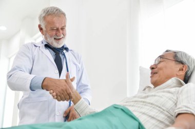 Üst düzey erkek doktor Asyalı erkek hasta ile konuşuyor.