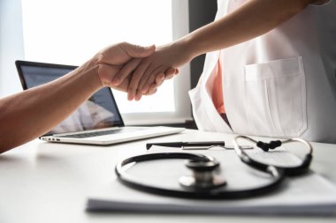Doktor kadın kıdemli erkek hasta el sıkışma.