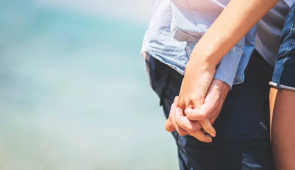 Casal no amor de mãos dadas sobre o mar, fundo da praia . — Fotografia de Stock