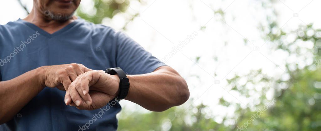 Asian Senior man checking cardio on smartwatch. Panoramic, Banne