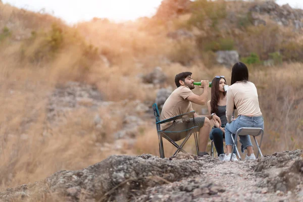 Happy Diversity friends enjoying camping in countryside with sunlight. Group of Multiethnic Traveler sitting relaxing in nature and mountain with copy space.