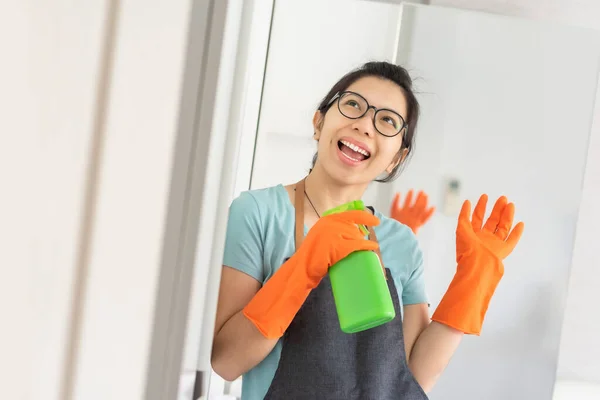 快乐的 身穿蓝色衬衫 头戴Apron和橙色橡胶手套的亚洲女人正在准备打扫她的房子 玩得开心 家务活 — 图库照片