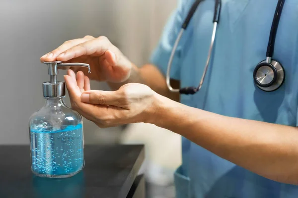 Doktor elleri temizleme ve dezenfekte için el dezenfekte jeli kullanıyor. Coronavirüs, Covid-19. Hastanedeki tıbbi odada çalışmadan önce.. 