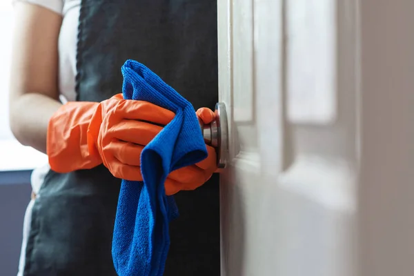女士手戴橙色橡胶手套 在接触门面时清洁 门把手用蓝色清洁布清洁 为卫生消毒 Coronavirus Covid 19预防概念 — 图库照片