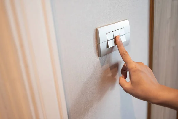 Close up of finger is turning on or off in light switch. Copy space.