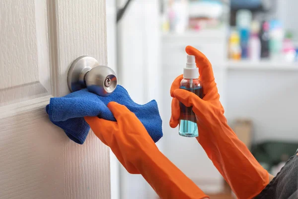 Vrouw Draagt Oranje Rubberen Handschoenen Schoonmaakdeur Deurknop Met Alcoholspray Huis — Stockfoto