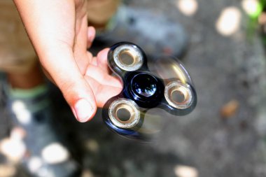 Değer değişimi veya fidgeting spinner çocuğun elinde dönen el