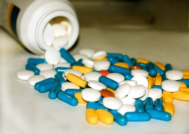 Çok renkli tabletler ve kapsüller şişeden boşalma