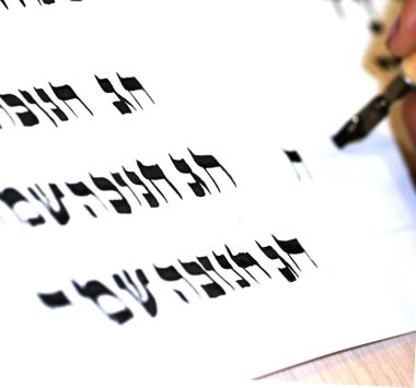 Kaligrafi İbranicede yazma. Elinde kalem. Ifade Chag Hanuka Sameach Mutlu Hanuka tercüme. Yazıcı sofer