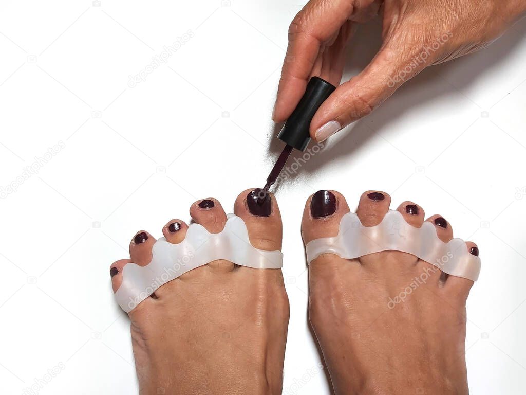 The master makes pedicures on toenails. Silicone finger device.