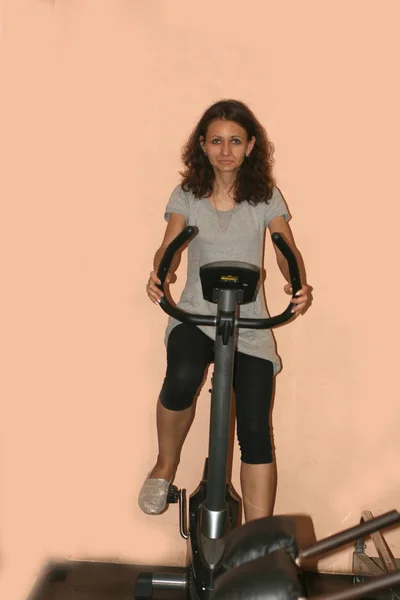 운동은 헬스 장에서 하고. 다리를 위한 파워 시뮬레이터. 운동 자전거. 체조. — 스톡 사진