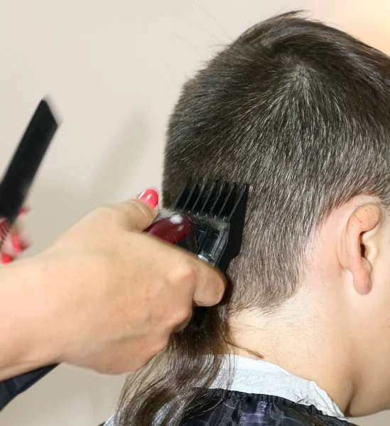 Haircut of a boy at the hairdresser. Trimer. — Stock Photo, Image