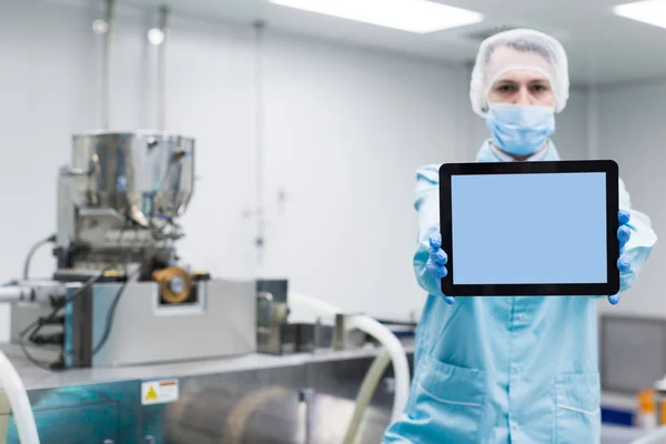 Scienziato mostra tablet vuoto vicino alle macchine — Foto Stock
