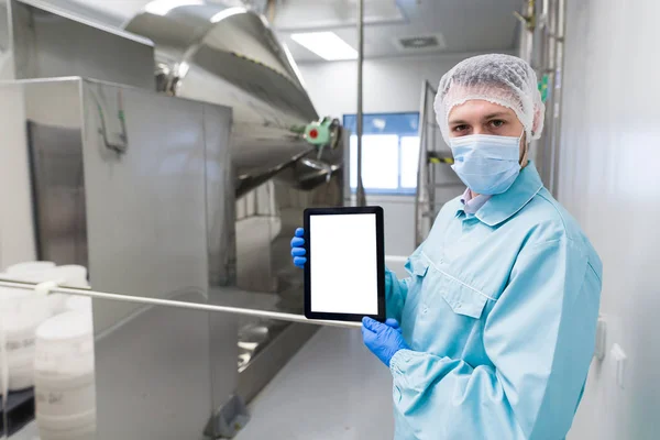 scientist show empty tablet near steel machine