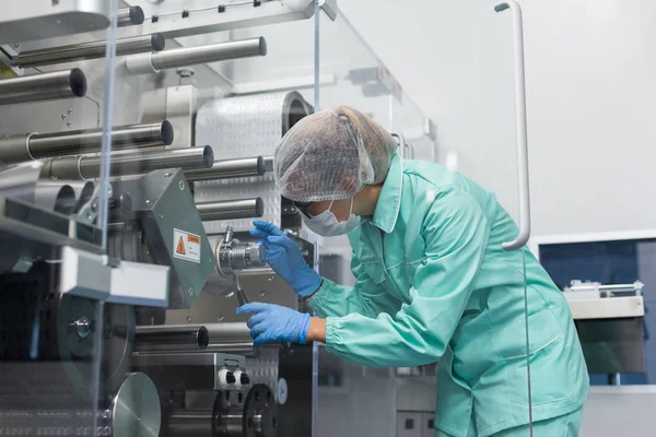 Trabajo del trabajador de fábrica con la máquina con los ejes — Foto de Stock