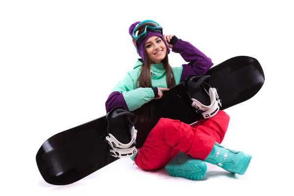 Красотка сидит на скрещенных ногах со сноубордом на коленях — стоковое фото