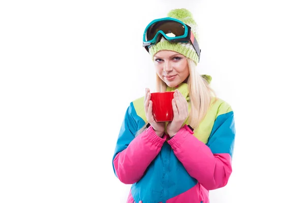 Милая женщина в лыжном костюме с красной чашкой — стоковое фото