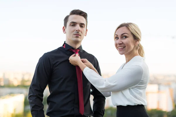 Девушка выпрямляет его галстук парень — стоковое фото