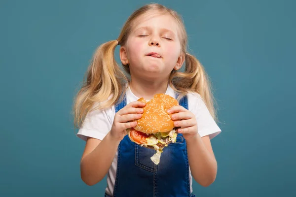 Маленькая блондинка с гамбургером — стоковое фото