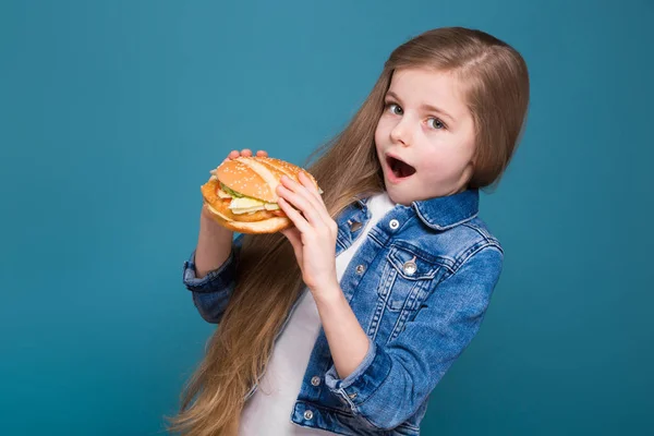 Маленькая порезанная девочка с гамбургером — стоковое фото