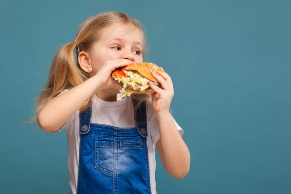 Hamburger ile küçük sarışın kız — Stok fotoğraf