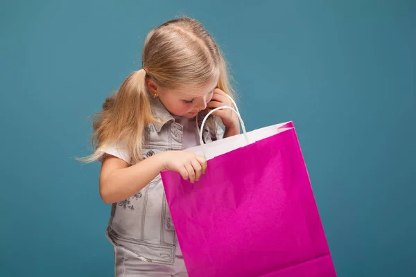 Ξανθό κοριτσάκι με χαρτί τσάντα — Φωτογραφία Αρχείου