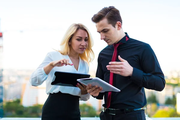 Pareja de empresarios con tabletas en el techo — Foto de Stock