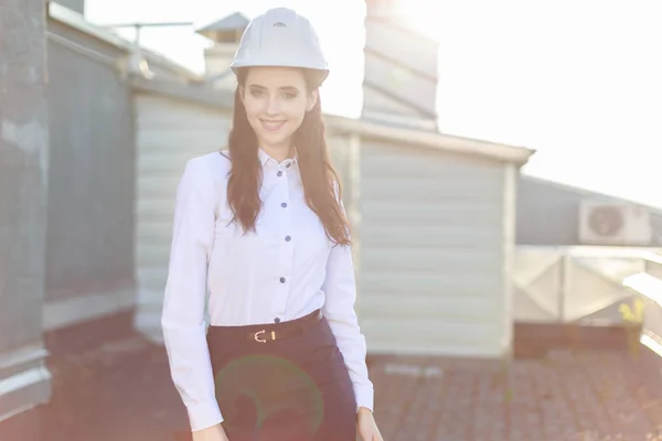 Attractive business lady in hardhat on the roof