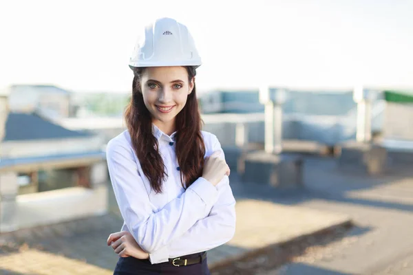 Attractive business lady in hardhat on the roof