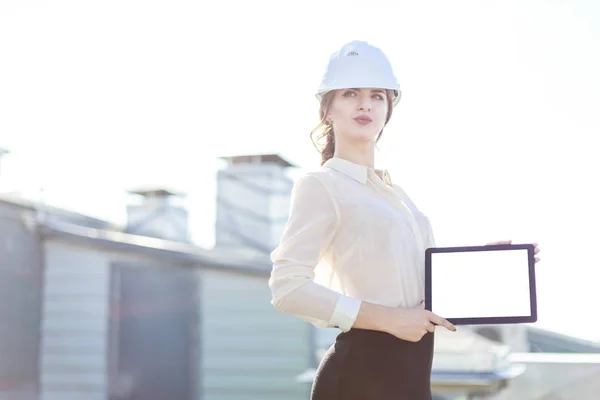 Mujer de negocios en casco en el techo con tableta — Foto de Stock